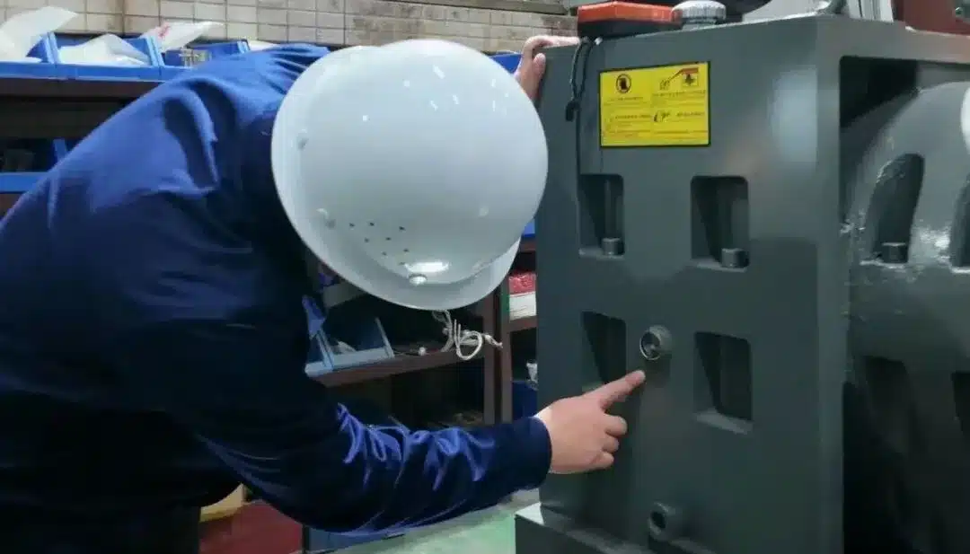 Technician checking the lubricating oil of a plastic pelletizing extruder